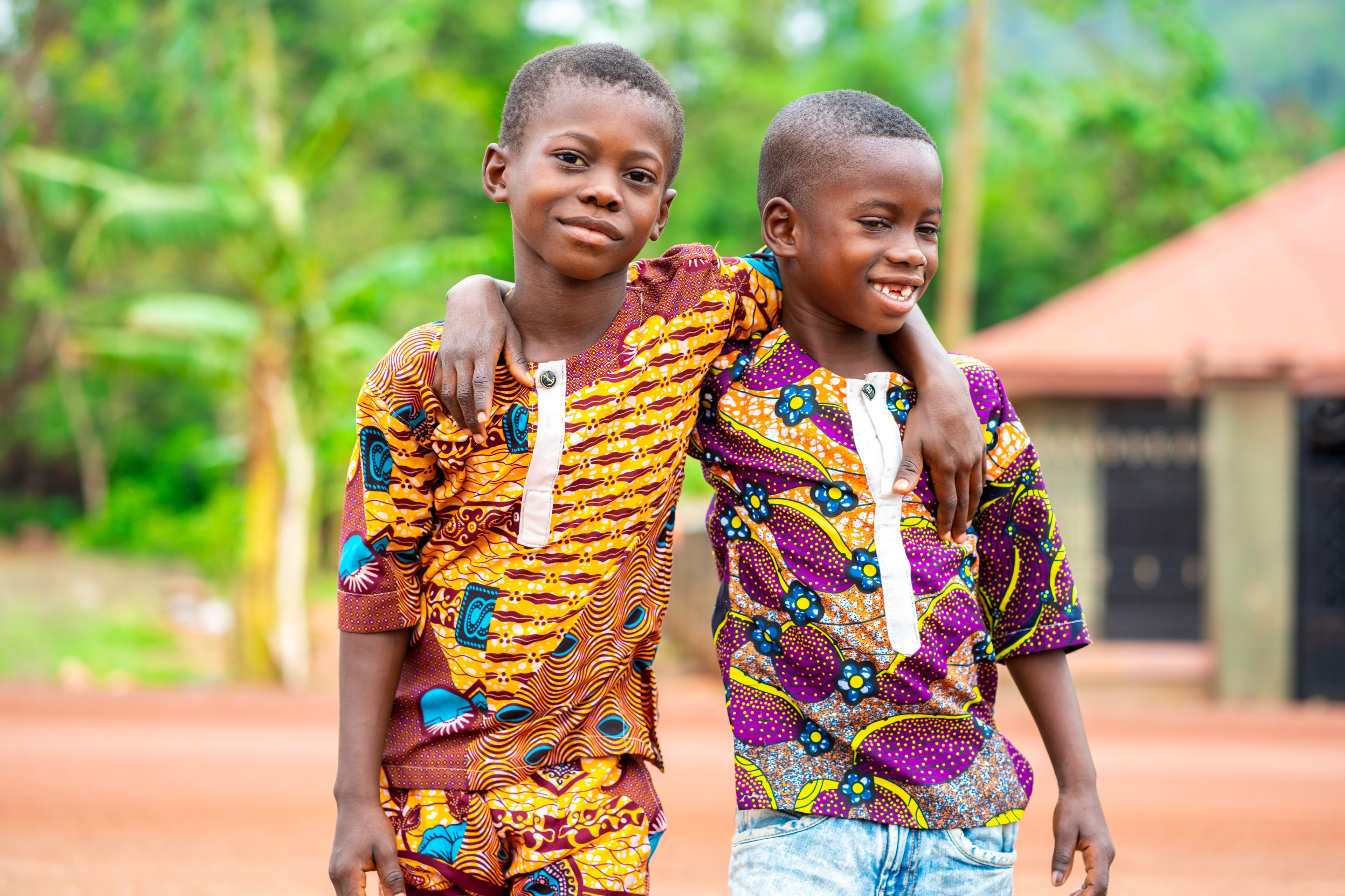 Two boys smiling, supported by community giving